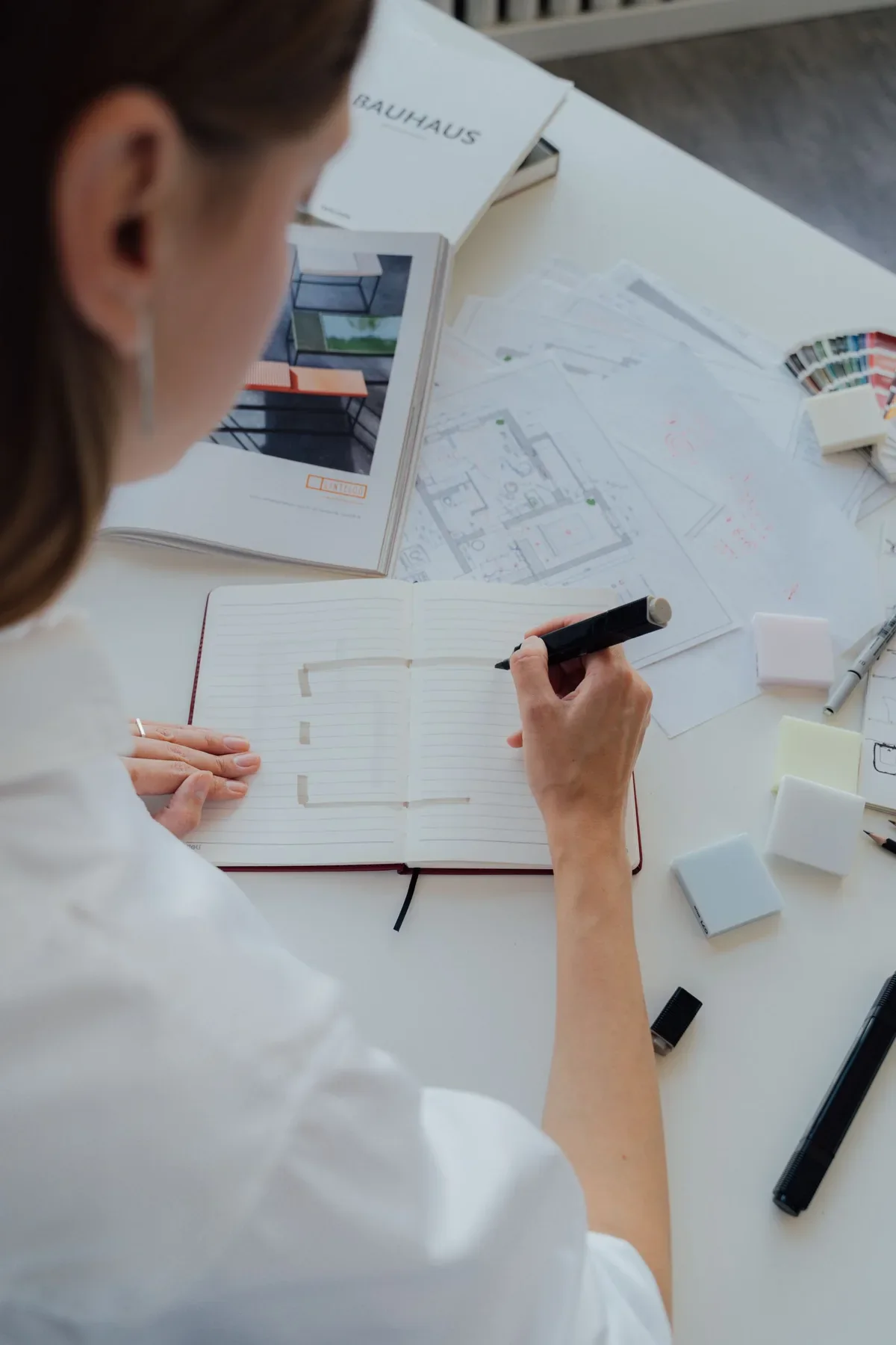 Designer working over architectural plans, used as temporary reference photography